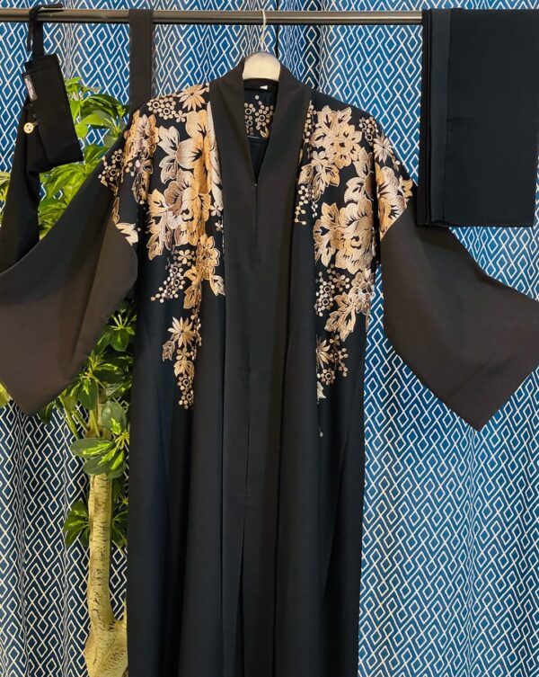Black Dubai abaya with earthy-tone floral embroidery on shoulders and sleeves