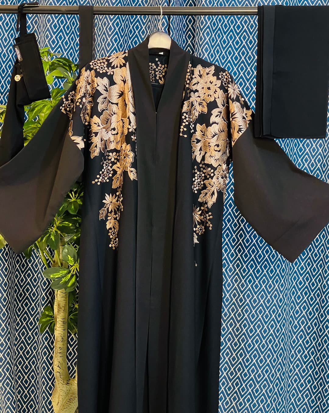 Black Dubai abaya with earthy-tone floral embroidery on shoulders and sleeves