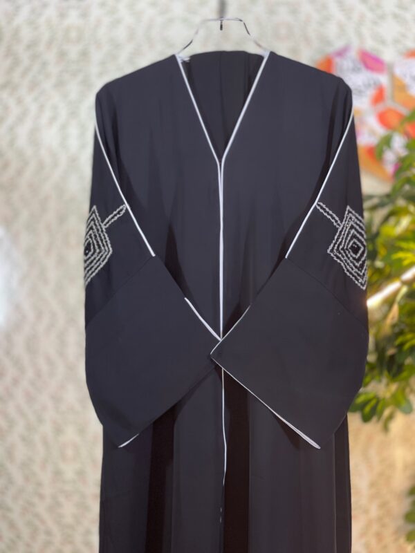 Elegant black Dubai abaya with double-layer sleeves featuring golden and transparent stonework